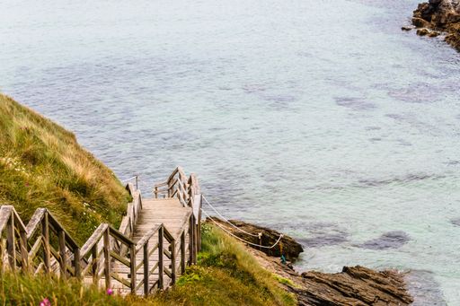 A majestic view of a wooden staircase leading to a grassy shore in Ferrol, Province of Coruna, Galicia