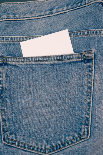 A vertical shot of a blank paper inside the pocket of a jeans