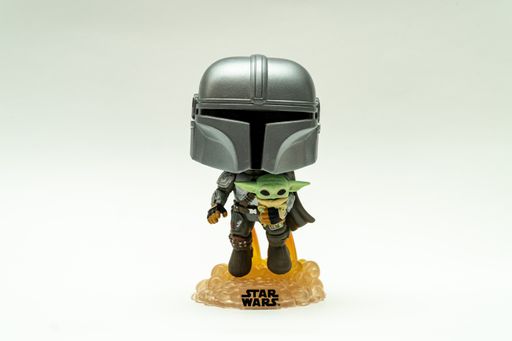 A horizontal shot of the funko pop from The Mandalorian with the child with rocking head from star wars