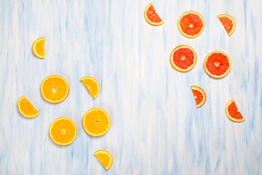 A top view of fresh grapefruit and orange slices isolated on the white-blue background