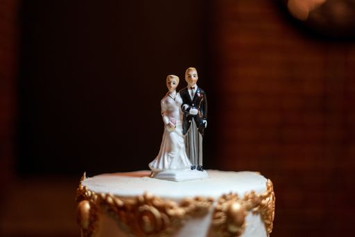 A selective focus shot of a wedding cake topper with a blurred background