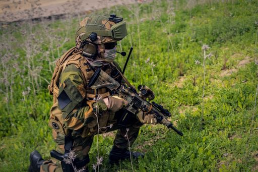 A closeup of a fully equipped soldier carrying out a military operation