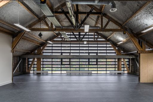 A wide shot of an empty warehouse wooden and steel beams
