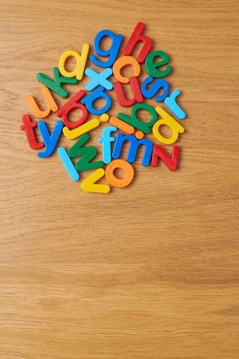 A top view shot of the colorful letters of the alphabet as a toy for children on the wooden table.