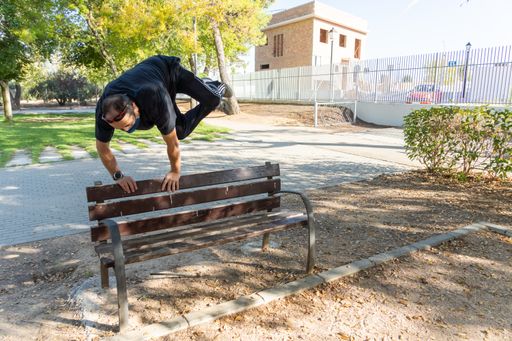Stock photo of man wearing face mask doing exercise in the park.