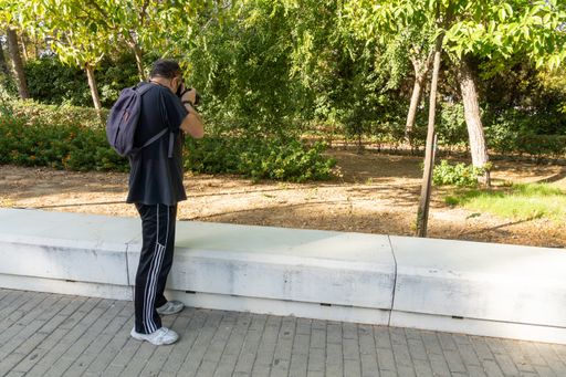 Stock photo of unrecognized man taking photos with his camera in the park.
