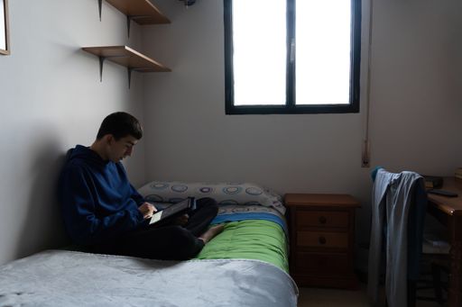 Stock photo of young boy playing in his tablet and sitting in the bed.