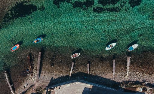 An aerial shot of several boats swimming through the water
