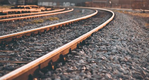 A beautiful shot of a railway surrounded by pebble stones during sunrise