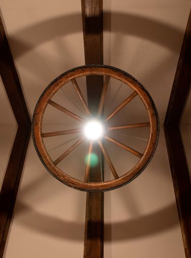 A vertical shot of the ceiling light in the form of a wooden wheel