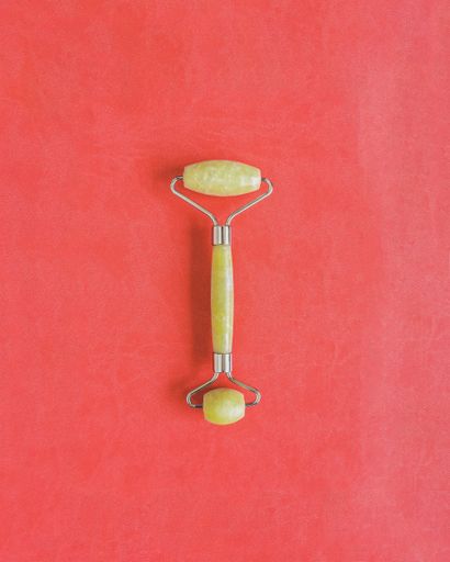 Skincare Quartz Roller on a pink background with copy space.