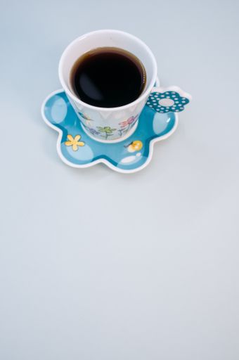 A vertical shot of a cup of coffee isolated on blue background
