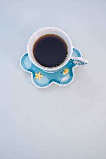 A vertical shot of a cup of coffee isolated on blue background