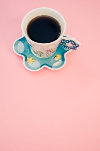 A vertical shot of a cup of coffee isolated on pink background