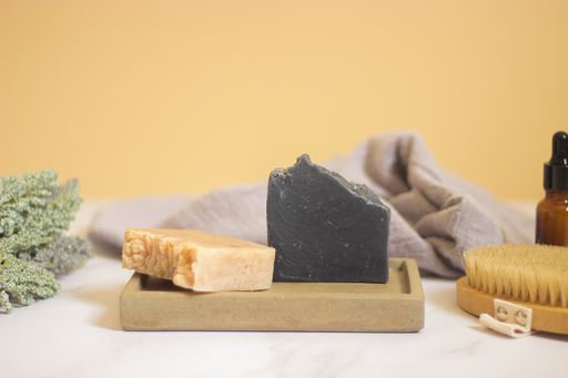 Two soaps and other beauty care products on a white table in the bathroom
