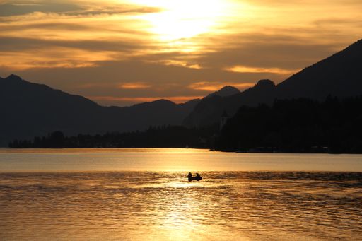 A mesmerizing view of a beautiful seascape at scenic sunset with mountains in the background