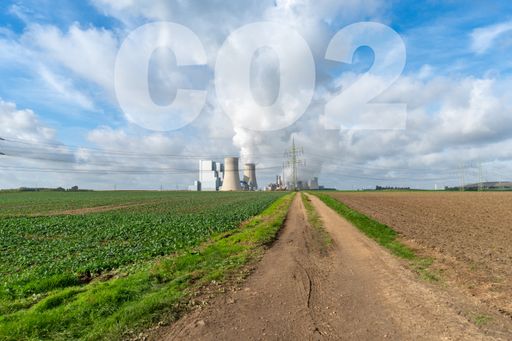 An agricultural field and an industrial buildings at the middle with chemical symbol of carbon dioxide