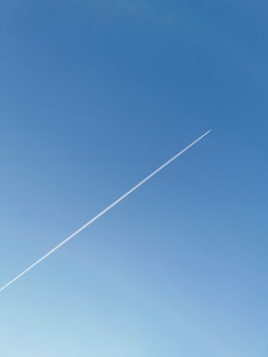 A low angle shot of the traces of an airplane in the blue sky