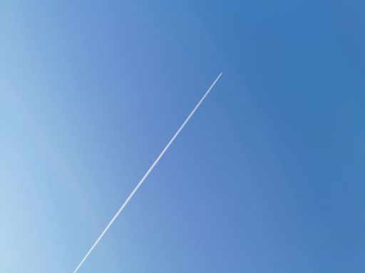 A low angle shot of the traces of an airplane in the blue sky