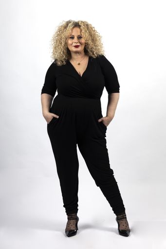 A vertical shot of a mature plus-size female model wearing black clothes on a white background