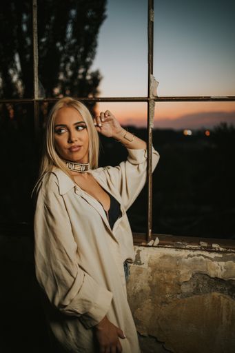 A vertical shot of a sexy Bosnian blonde woman wearing a crop top posing in an abandoned building