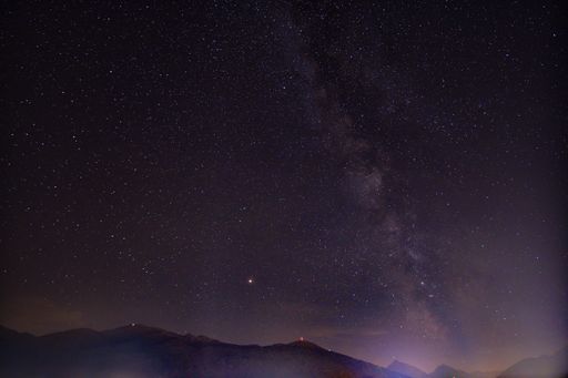 A starry sky during the night above rocky mountains - a cool picture for backgrounds and wallpapers