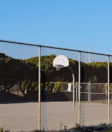 An empty basketball court outside at the beach on a sunny day
