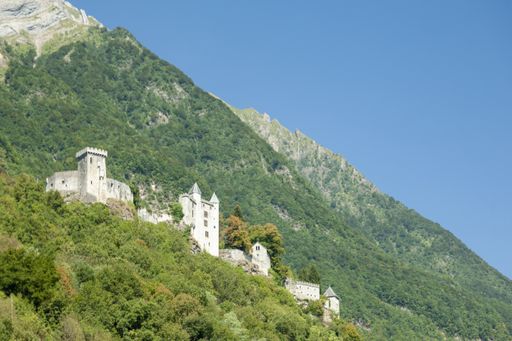 A beautiful low angle shot of the Fortress of Miolans on mountain hills surrounded by greenery