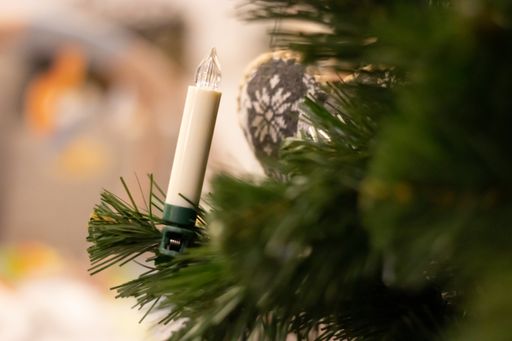 A selective focus shot of a LED candle in the christmas tree with a blurred background