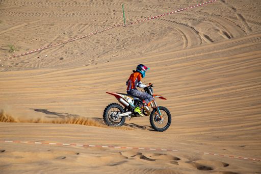 Motorcross bike and rider riding on the sand in a desert race