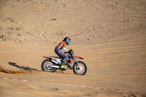 Motorcross bike and rider riding on the sand in a desert race