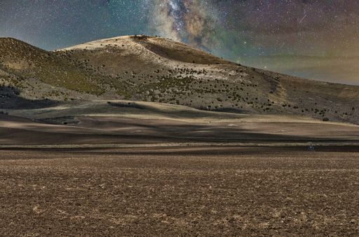The beautiful starry sky over the mountains and dry fields