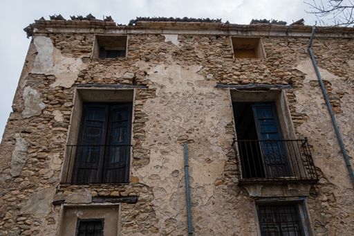 A low angle shot of an old stone building with small balconies