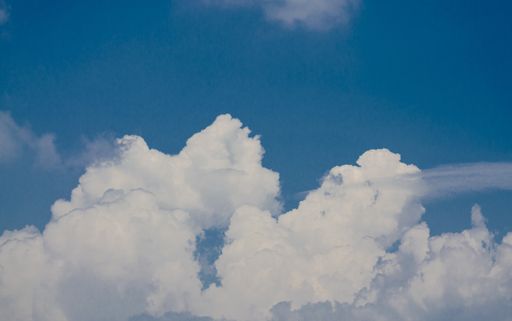 A wallpaper depicting white clouds on a blue sky background