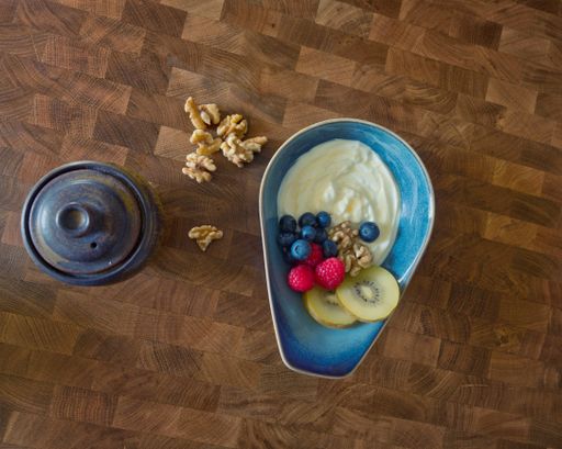 A top view of yogurt with fruits and nuts on a table