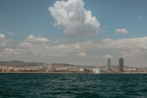 The horizontal shot of the boat in the sea port under the cloudy sky in Barcelona, Spain