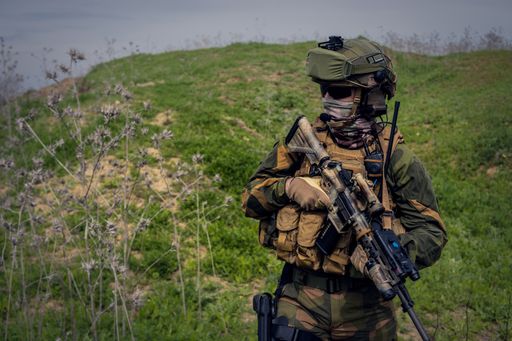 A closeup shot of an armed soldier on a landscape