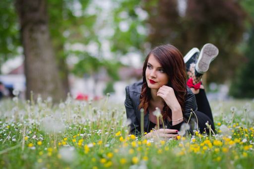 A young Bosnian woman laying on the grass in the park