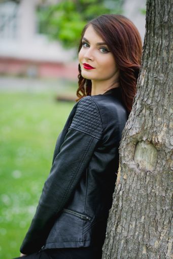 A young Bosnian woman with a red lipstick posing in the park