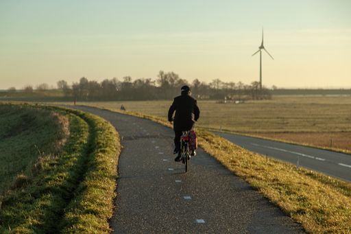 A lonely cyclist in the road of netherlands at sunrise