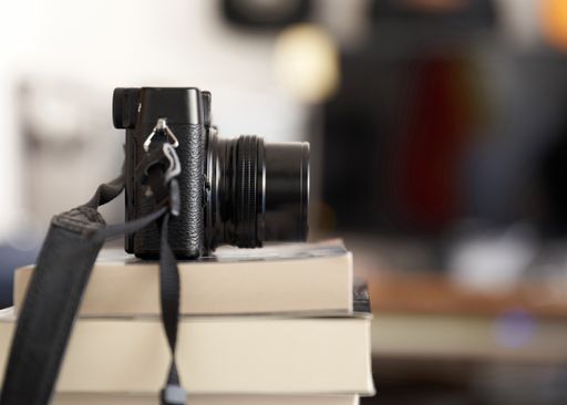 A vintage camera on a pile of books
