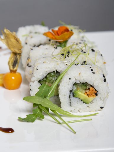 A vertical shot of vegan sushi rolls on a white plate