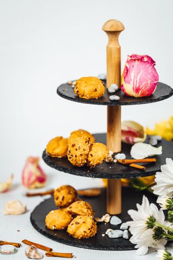 A vertical shot of various types of cakes and biscuits on a cake stand