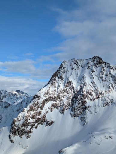 A vertical shot of a scenic view of a snow covered mountain peak