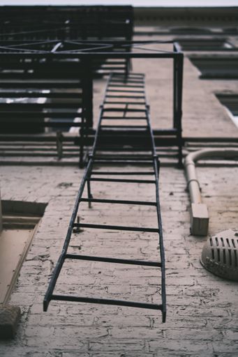 A vertical low angle shot of a metal ladder on a building