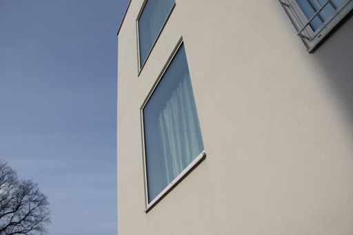 A low-angle shot of a modern building with many windows against the clear blue sky