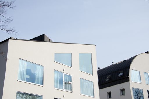 A low-angle shot of a modern building with many windows against the clear blue sky