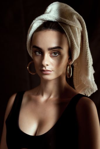 A vertical shot of a young woman with a towel on her head