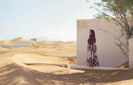 A female walking in the desert through the abandoned town of Al Madam, UAE