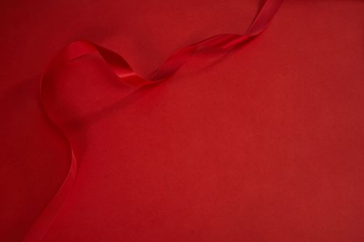 A high angle shot of a red ribbon isolated on a red background